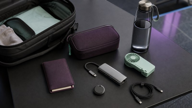 Compact travel backup kit arranged in a day bag with organized tech and comfort essentials